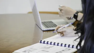 a person writing on a piece of paper
