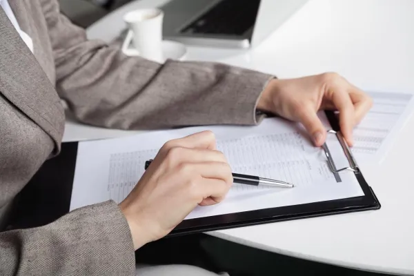 a person writing on a piece of paper
